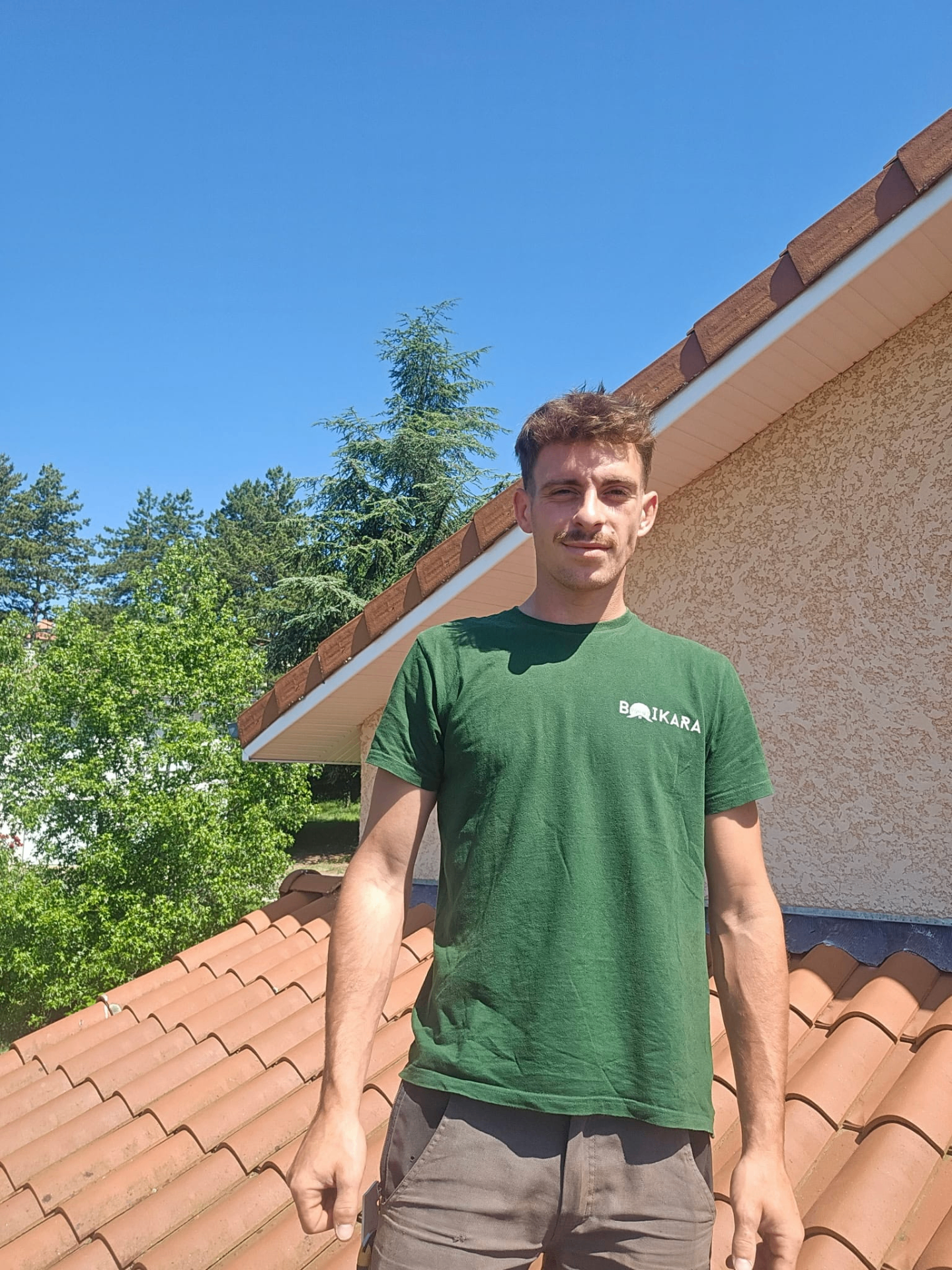 Artisan charpentier Boikara devant une toiture